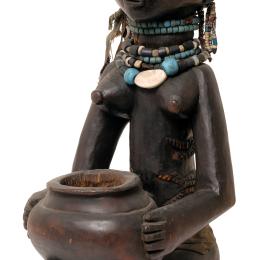 Luba Hemba, ateliers de MALEMBA NKULU, porteuse de coupe, République démocratique du Congo, fin 19e – déb. 20e s. Ricinodendron, pâte de verre et coquillages. 42 x 23,5 x 19,5 cm. N° inv. A48. Fonds ancien de l’Université (don Pères Blancs).